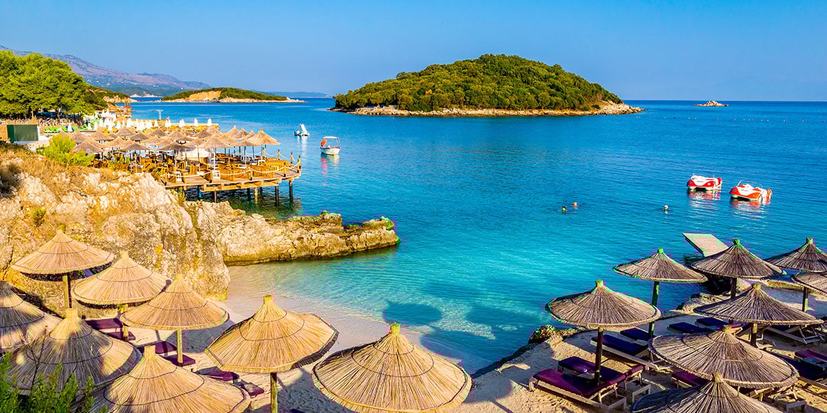 Strand med parasoller og turkist vann