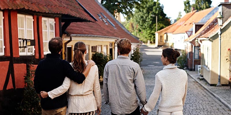 Venner går gjennom en gate med typisk danske små trehus