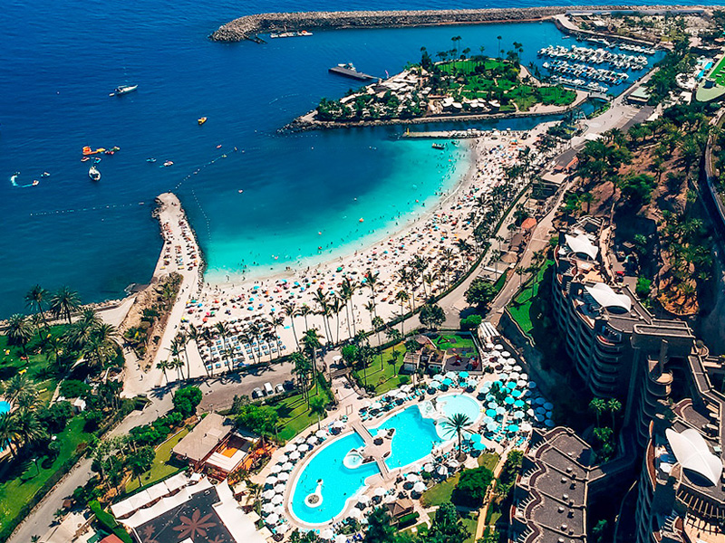 fugleperspektiv av strand og badebasseng med turkist vann