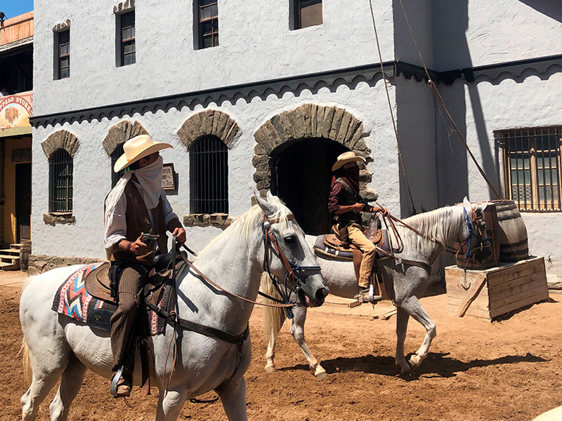 to cowboyer på hvite hester i en by i western stil