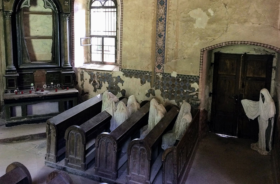 gammel og endslitt kirke med spøkelsesstatuer