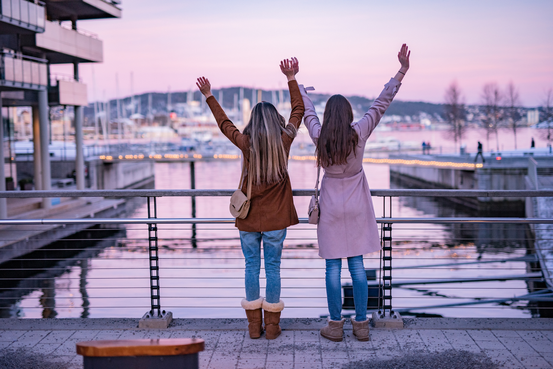 To venninner står med armene i været mens de ser utover havet ved Tjuvholmen