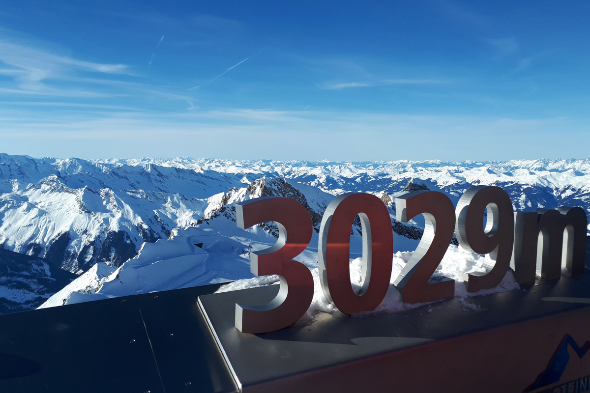 skilt med 3029m foran høye, spisse fjell