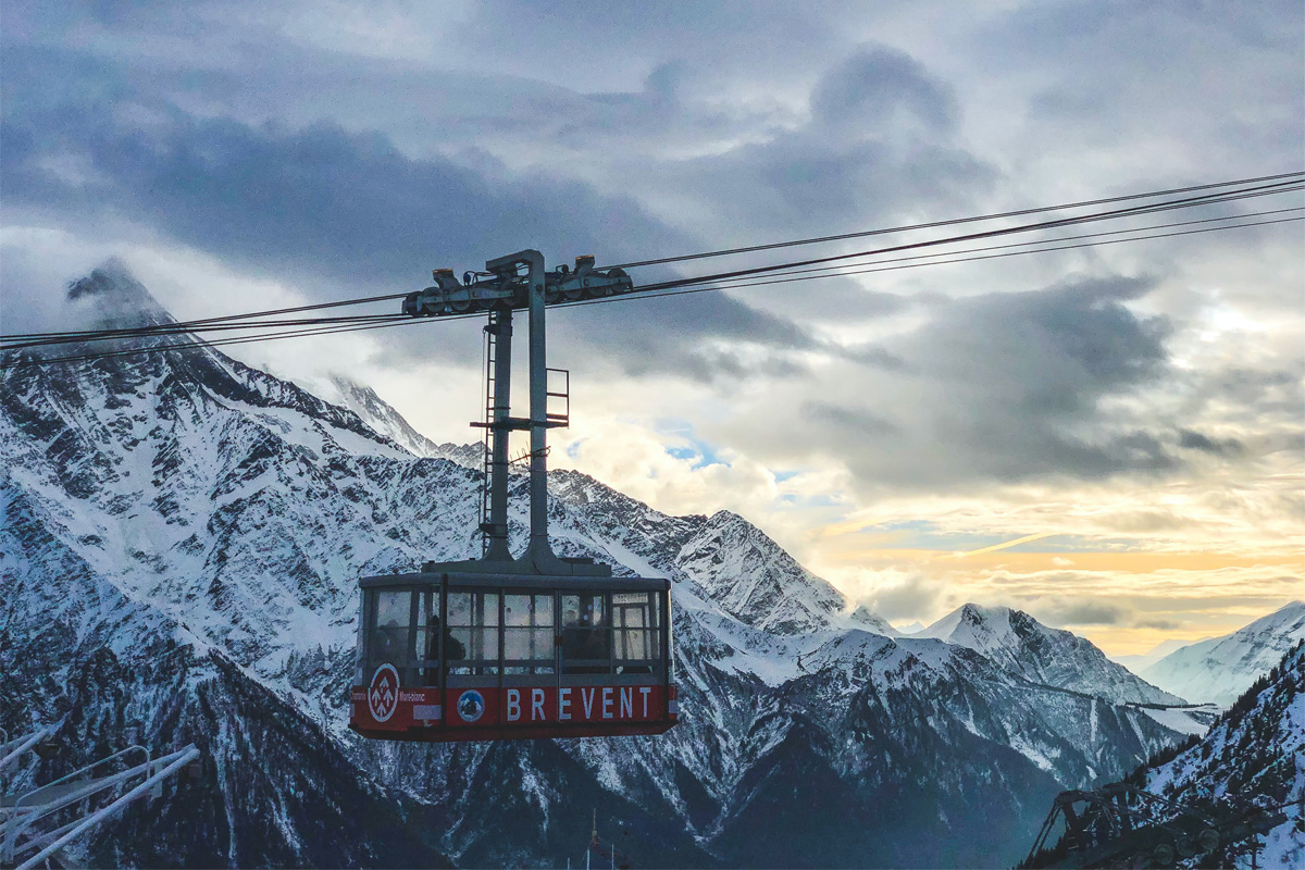 gondolvogn i solnedgang foran spisse fjell