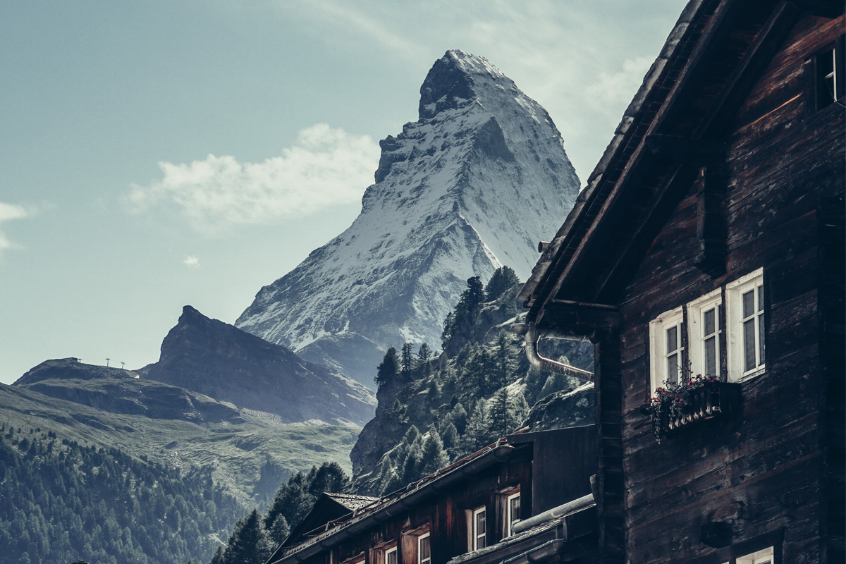 Matterhorn i bakgrunnen med typiske sveitsiske hus i forgrunnen