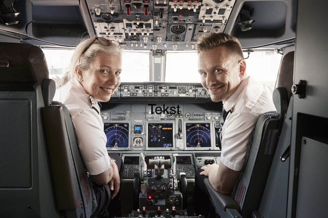 To piloter smiler mens de sitter i cockpit