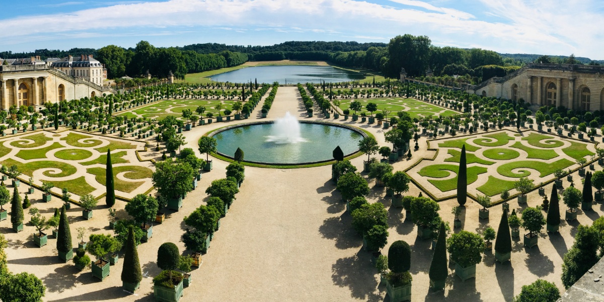 Hagen i Versailles med velstelte planter, fontene og innsjø