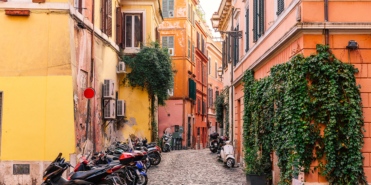 Smalt smug i Roma, med mopeder langs med veggen