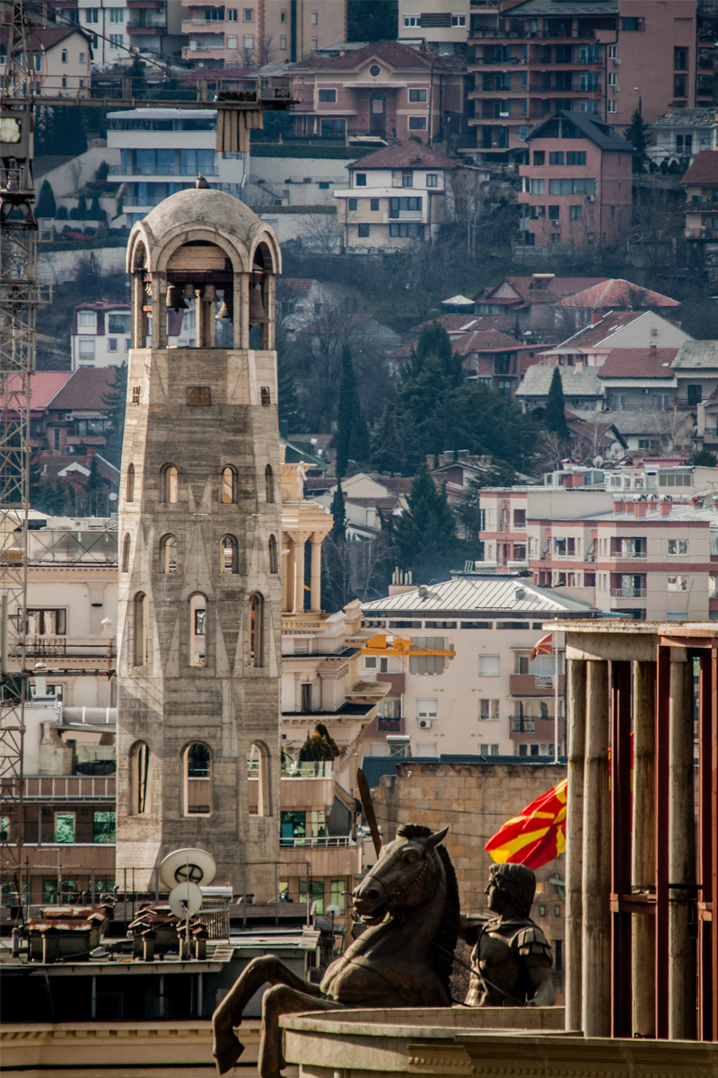 oversiktsbilde av skopje med gule mursteinshus og statue av Alexander den store på hest
