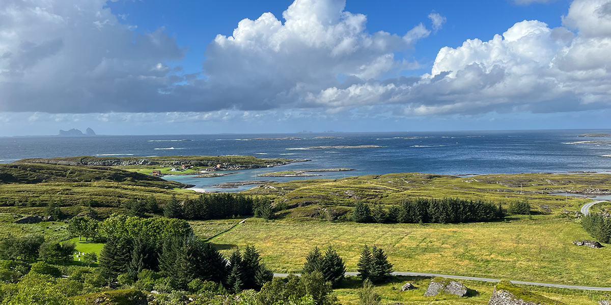 Et kystlandskap med øyer, hav og grønn slette