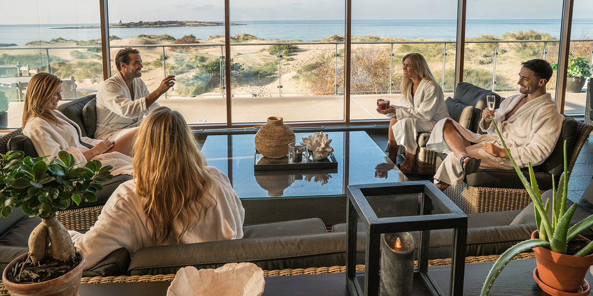 Mennesker som sitter en relax-avdeling i en Spa med vakker utsikt til strand og hav